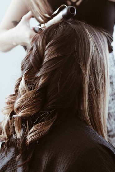 Hairdresser curling a client's hair